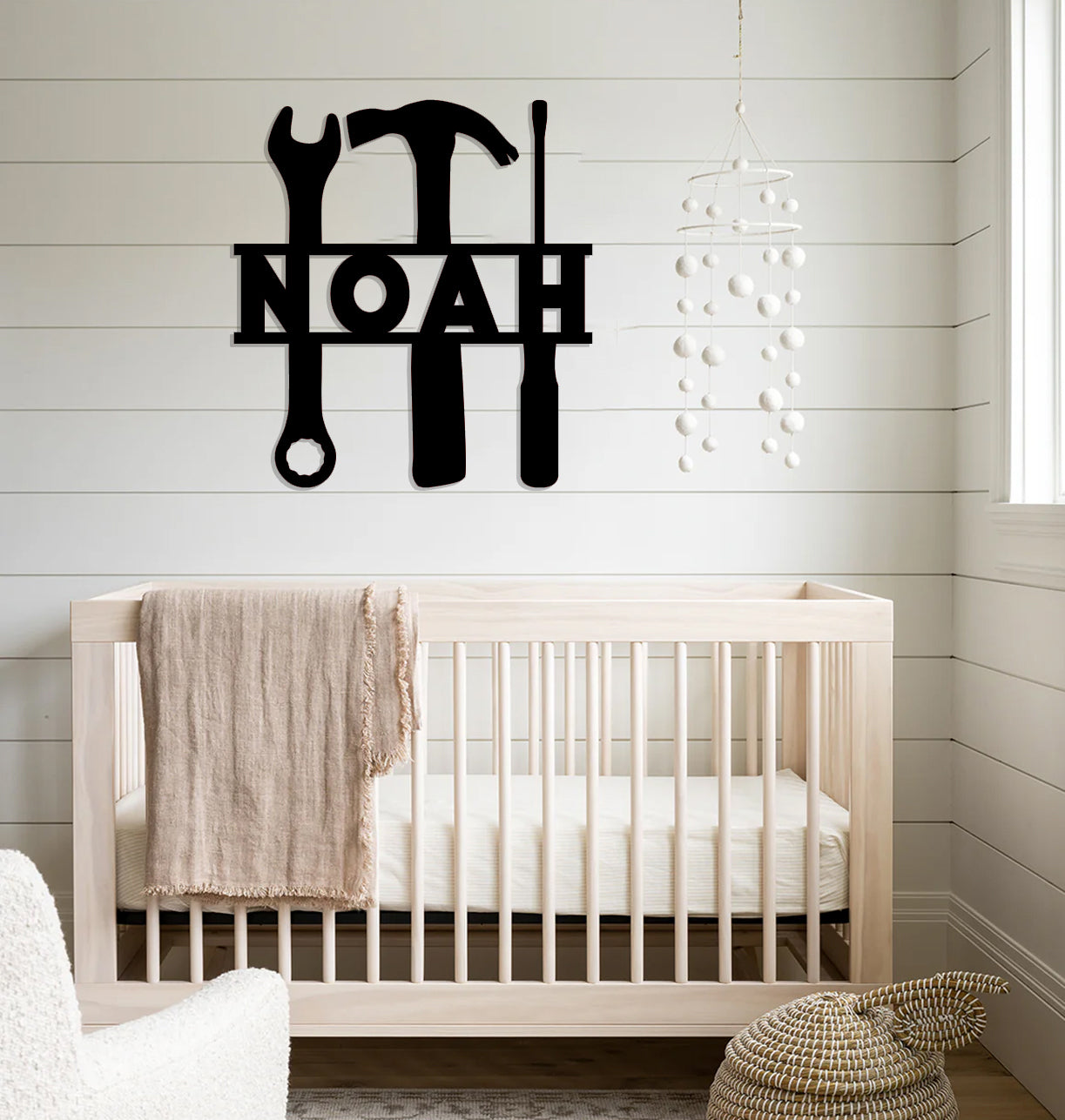 a baby's room with a white crib and a wall hanging with a